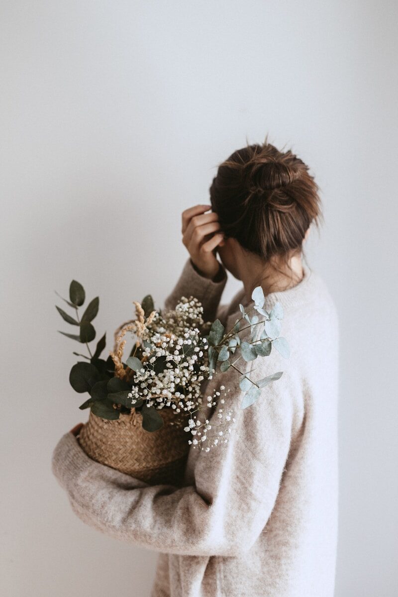 how to increase feminine energy woman carrying white flower plant